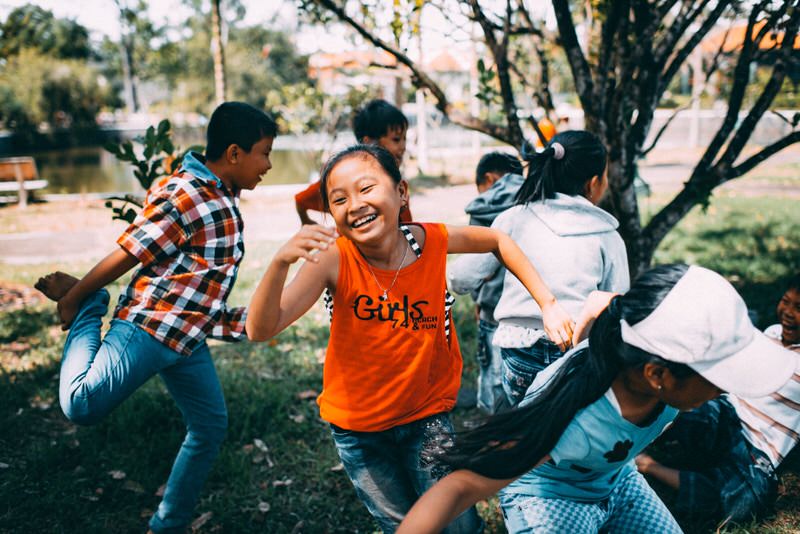 A group of young kids play in a park