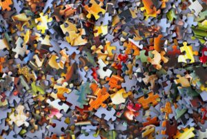 A close up image of mixed-up puzzle pieces.